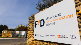 A sign against a rock wall with Broadland Food Innovation Centre written on it