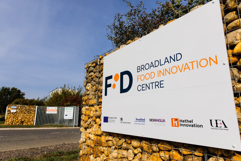 A sign against a rock wall with Broadland Food Innovation Centre written on it